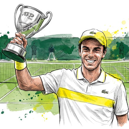 Tennis player in a white and yellow shirt holding up a silver trophy on a green court, smiling after a win.