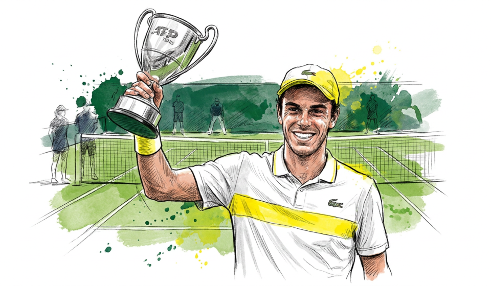 Tennis player in a white and yellow shirt holding up a silver trophy on a green court, smiling after a win.