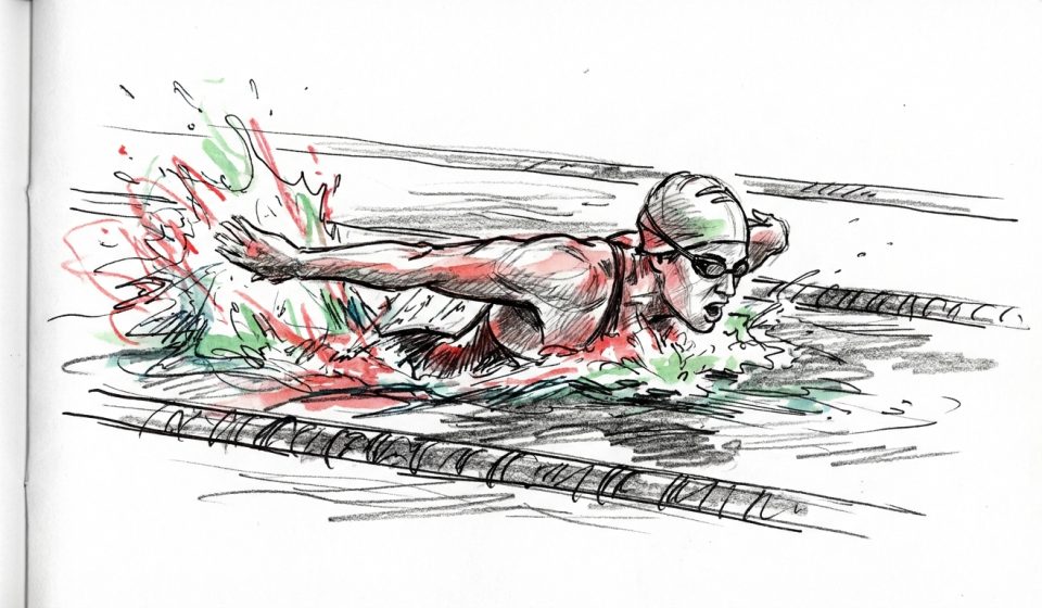 Swimmer in goggles performing freestyle stroke in a pool, arms extended and water splashing around.